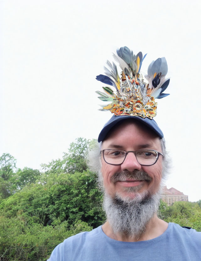 Smiling person with graying beard in colorful floral cap