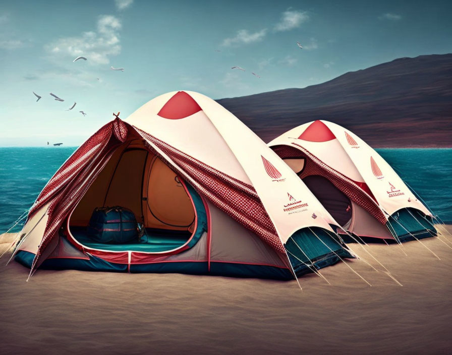 Red and white tents on sandy beach with birds and mountain view