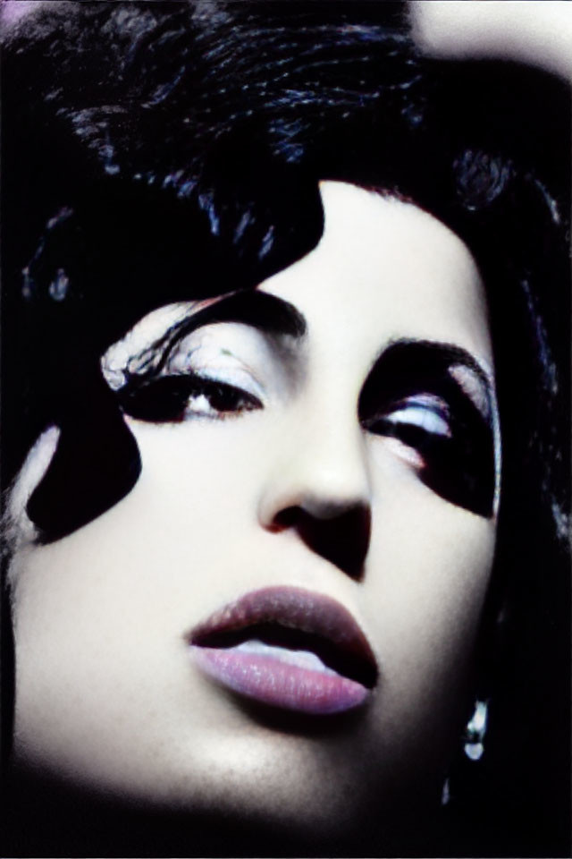 Portrait of woman with dark wavy hair and dramatic makeup in moody lighting