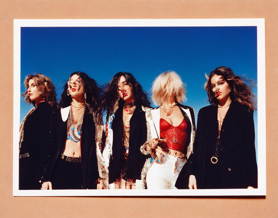 Five Stylish Individuals Posing in Vintage Outfits against Blue Sky