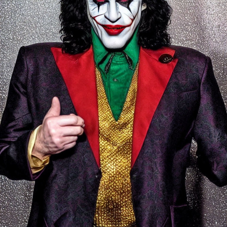 Character in Red and Black Joker Costume with Green Shirt and Gold Vest Giving Thumbs-Up