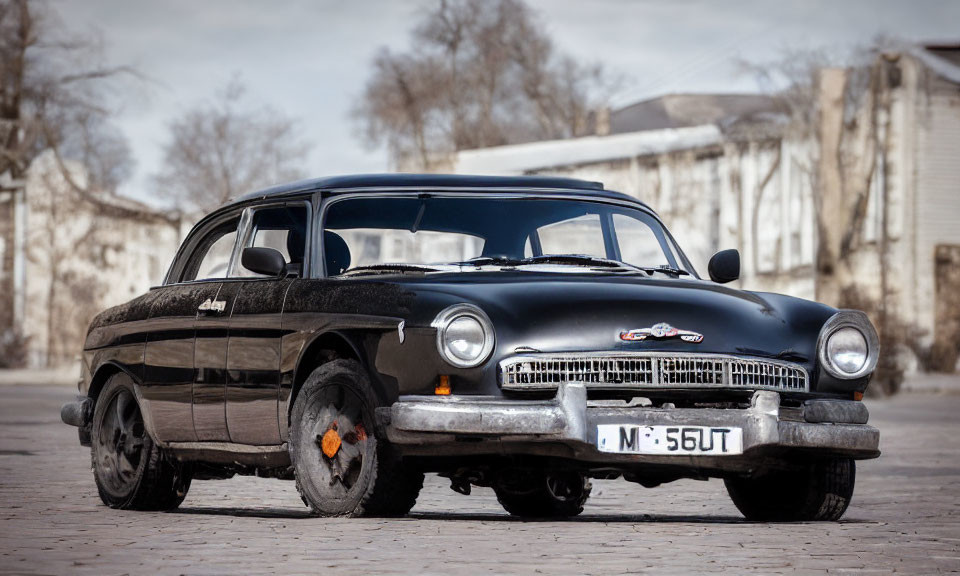 Vintage Black Car with Chrome Detailing and White-Wall Tires on Paved Area