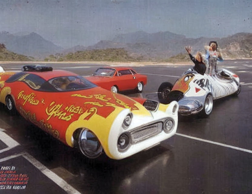 Custom-painted hot rod cars on mountain road with waving people