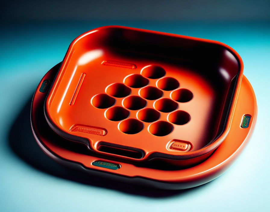 Orange Plastic Ashtray with Built-In Cigarette Holders on Blue Surface