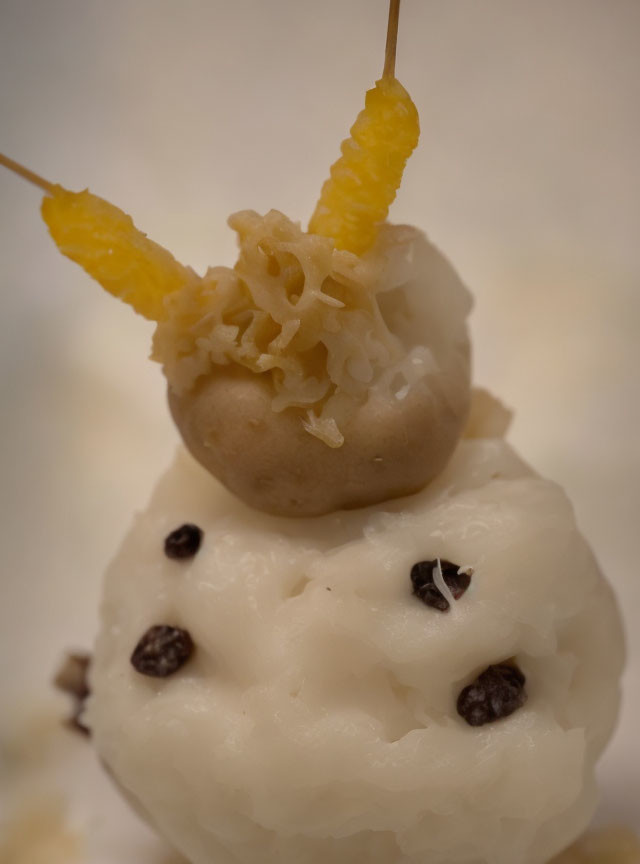 Snowman-shaped rice dessert with raisin buttons and candied fruit arms