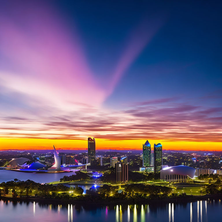 City skyline at sunset with purple clouds, skyscrapers & waterfront park