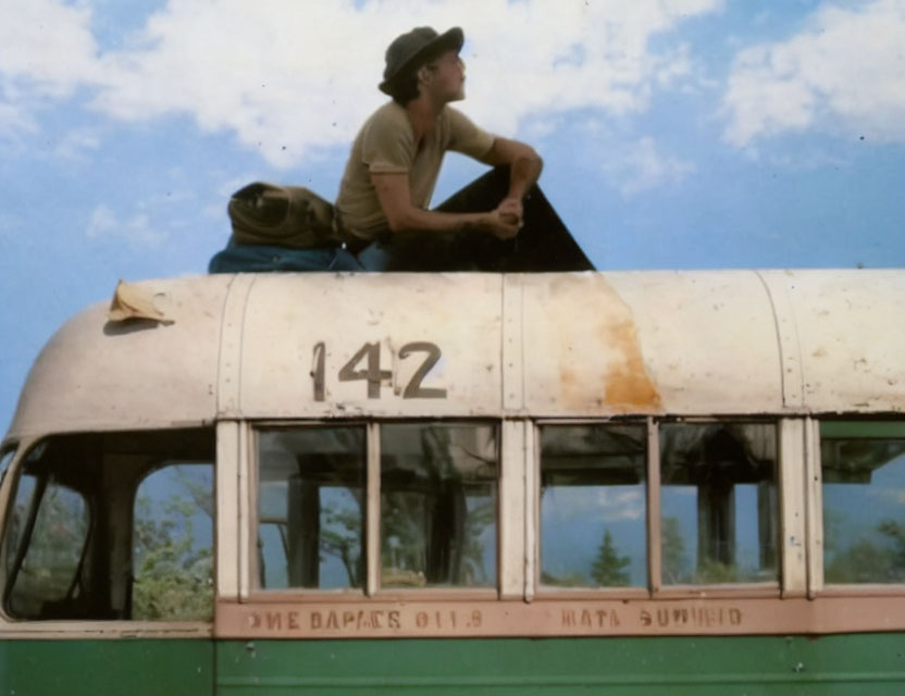 Person sitting on vintage bus number 142 under clear sky