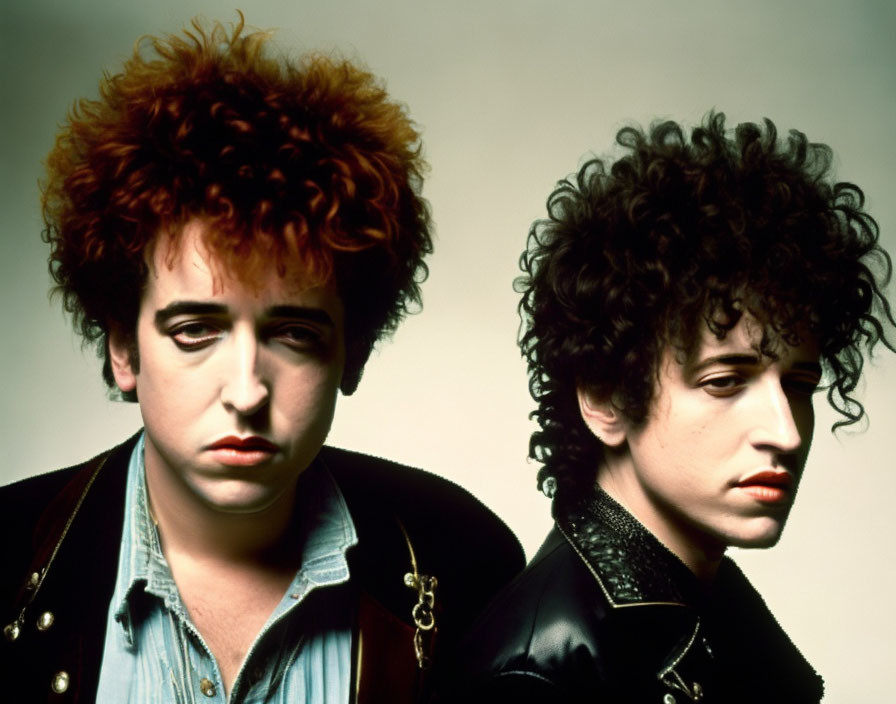 Portrait of two individuals with voluminous, curly hair, one facing forward and the other in profile,