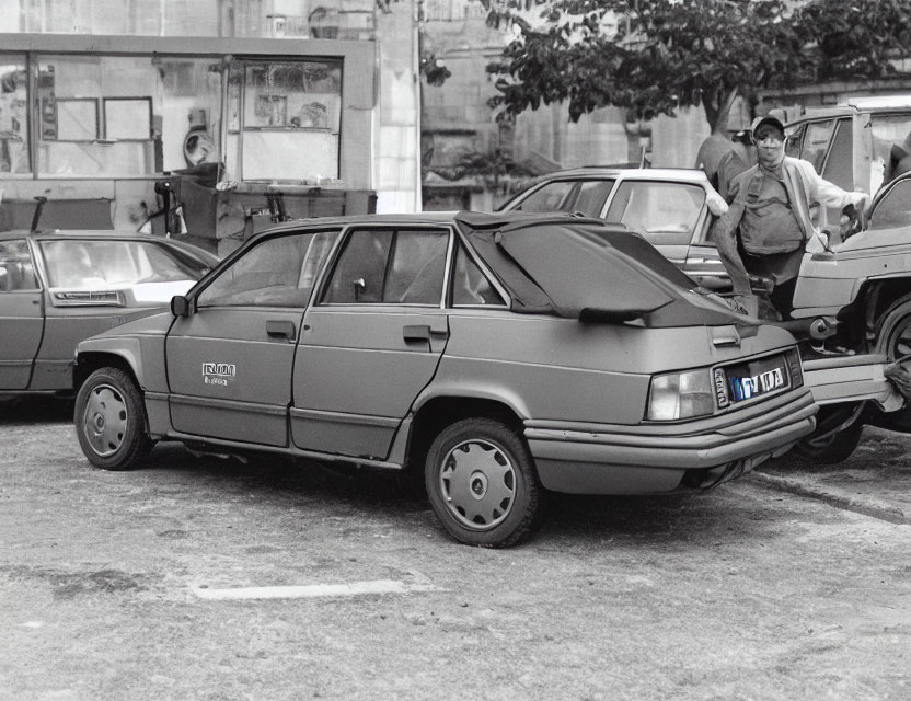 Monochrome photo of vintage sedan on city street