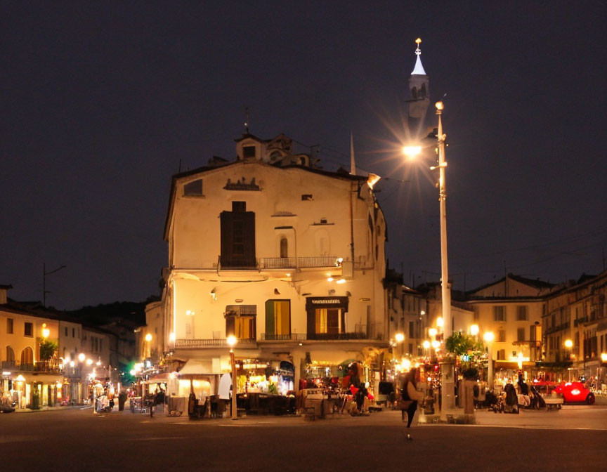 European Town Square Night View with Illuminated Buildings and People