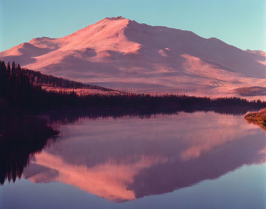 Tranquil mountain reflected in still lake at sunrise