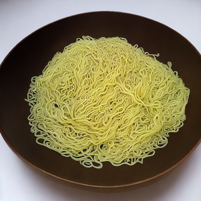 Neatly arranged uncooked instant noodles in dark bowl