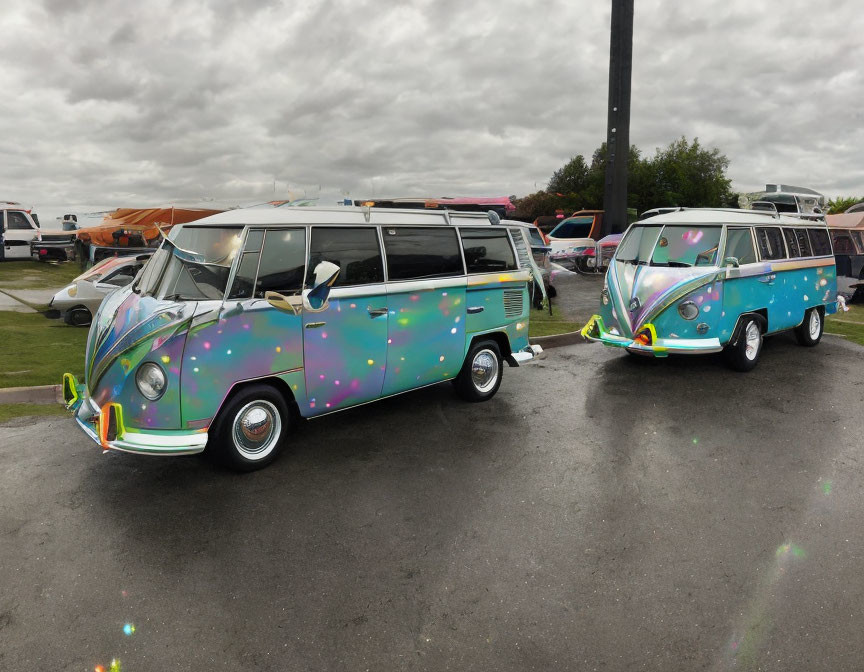 Vintage Volkswagen buses with custom paint jobs parked on wet surface among other vehicles