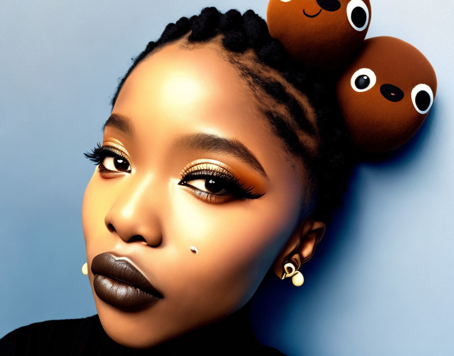 Portrait of woman with braided hair and bear-shaped hair accessories, dramatic makeup on blue background