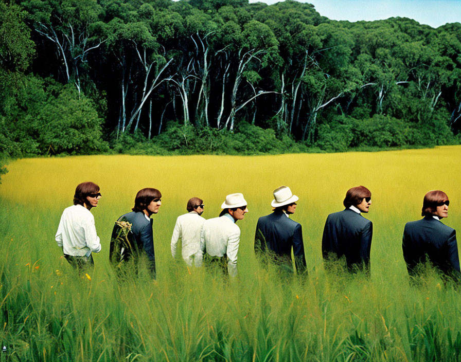 Seven people in suits and hats in a field with tall yellow grasses