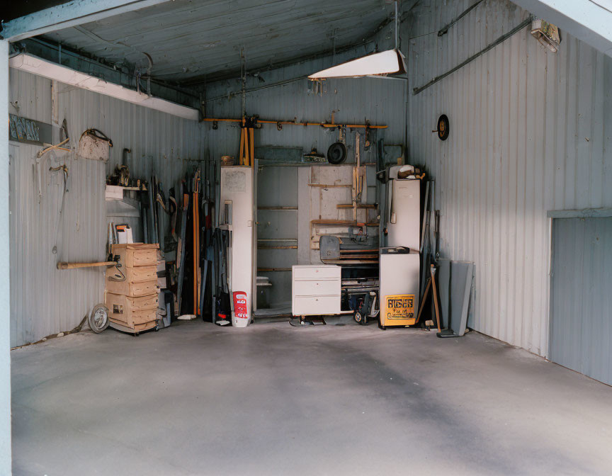 Organized Garage with Tools, Workbench, Fridge, and Wooden Crates