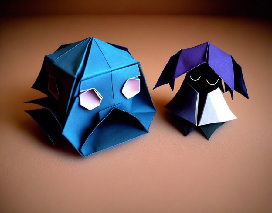 Origami figures: blue and purple stylized characters on brown background