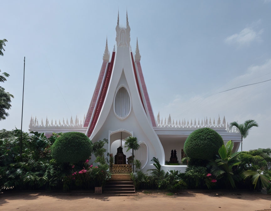 White Building with Red and White Pointed Facade Against Blue Sky