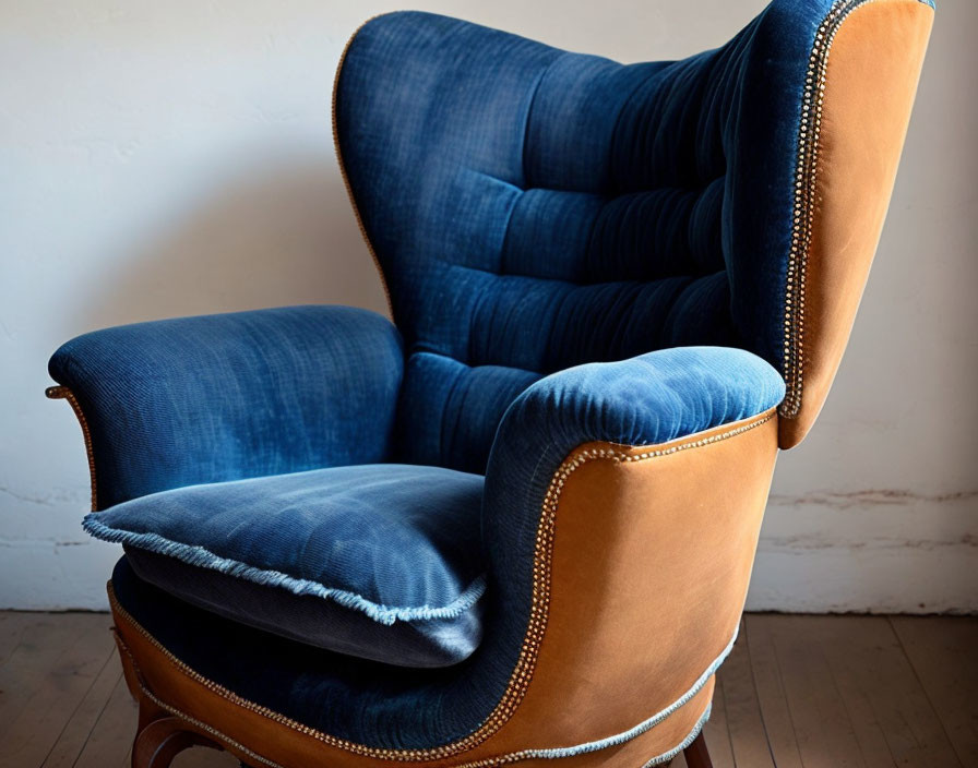 Blue Upholstered Wingback Chair with Tufted Design and Brass Nailhead Trim on White Wall