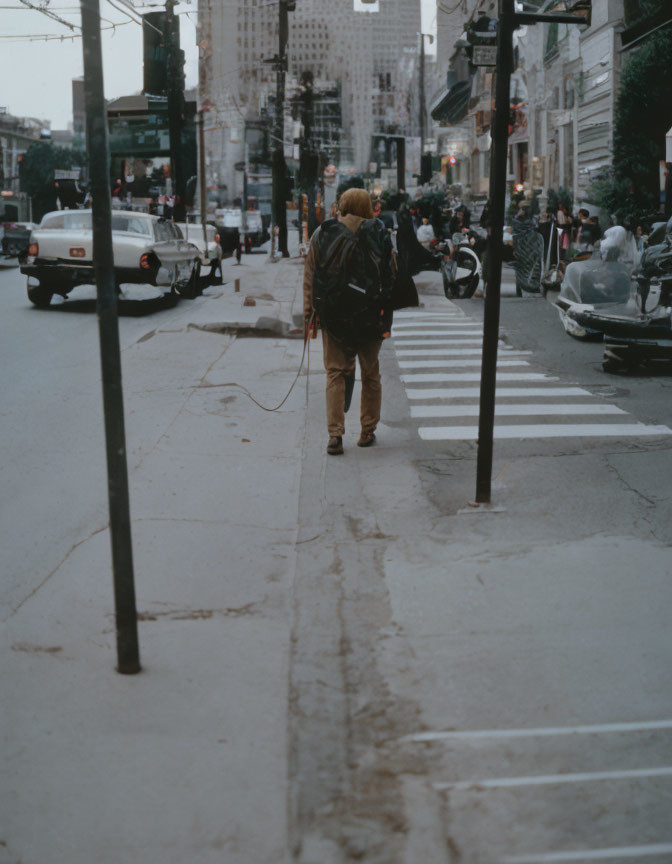 Pedestrian with backpack and headphones near zebra crossing in urban setting