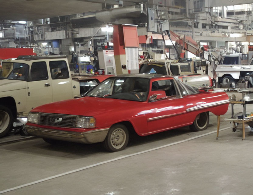 Vintage Red Car Parked in Industrial Garage with Machinery