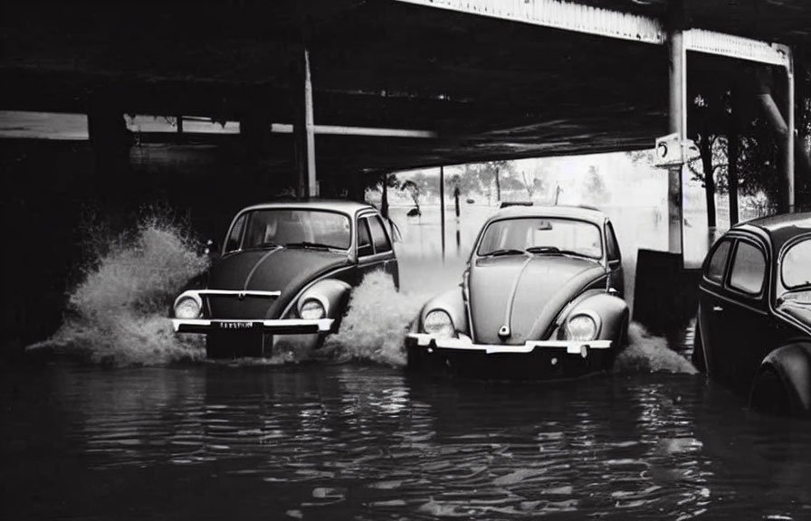 Classic cars navigating flooded underpass with water halfway up.