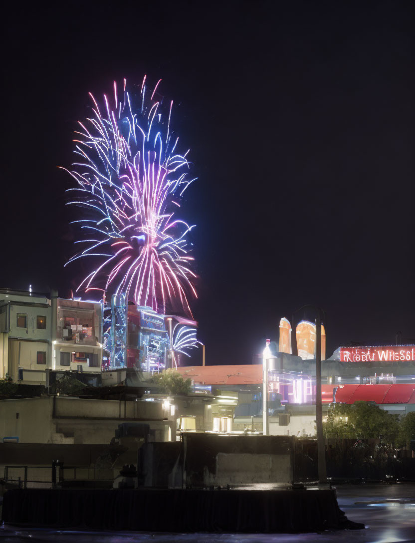 Vibrant fireworks illuminate city waterfront at night