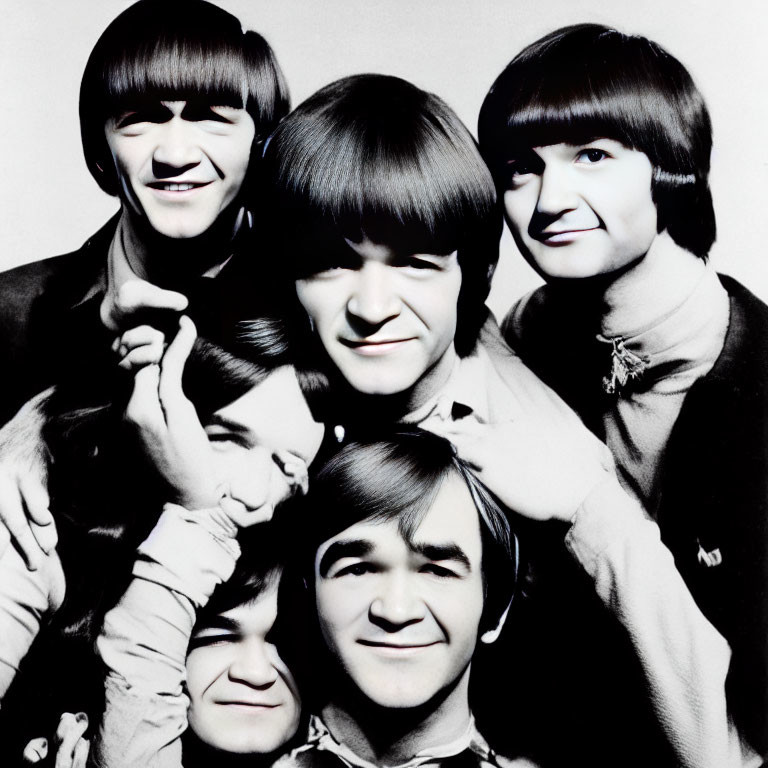 Group of men with bowl haircuts smiling in black and white photo