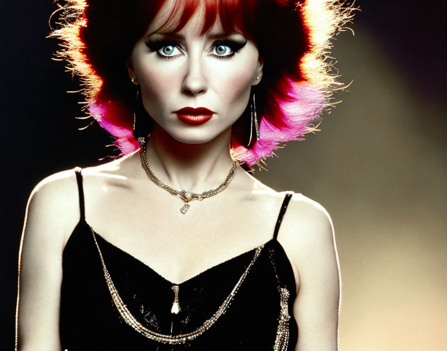 Red-haired woman with striking makeup in black top and necklace on dark background