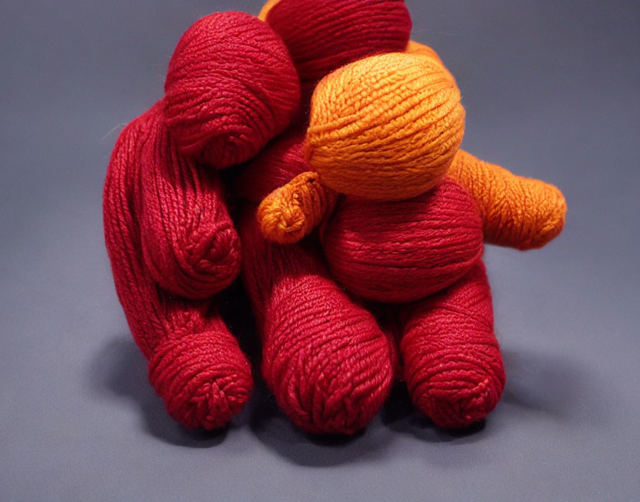 Red and Orange Yarn Figure on Blue Background