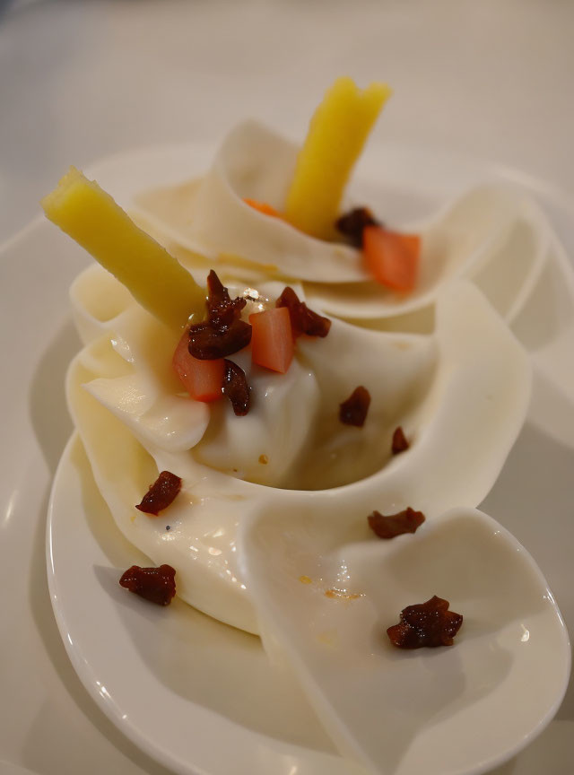 White Dumplings with Yellow Slices and Garnish on White Plate