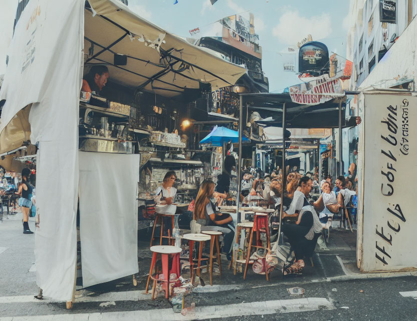 Busy City Street Café Scene with Outdoor Patrons and Buildings