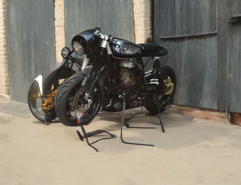 Black Motorcycle Parked in Front of Closed Garage Door with Brick Wall Background