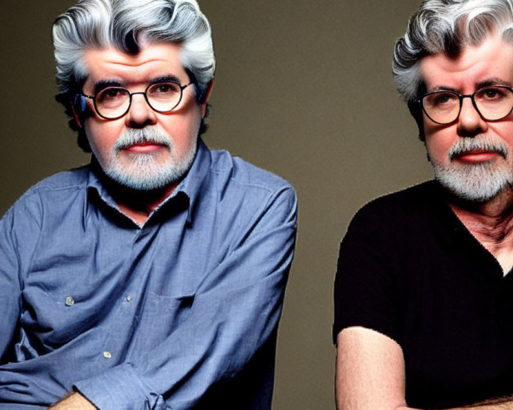 Two gray-haired men with beards and glasses in blue and black shirts on gray background