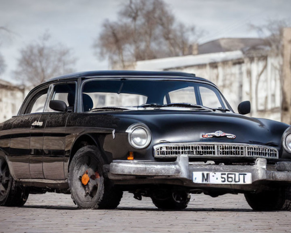 Vintage Black Car with Chrome Detailing and White-Wall Tires on Paved Area