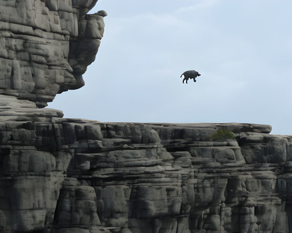 Silhouette of person levitating above rugged cliff in cloudy sky.