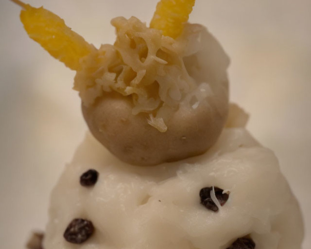 Snowman-shaped rice dessert with raisin buttons and candied fruit arms