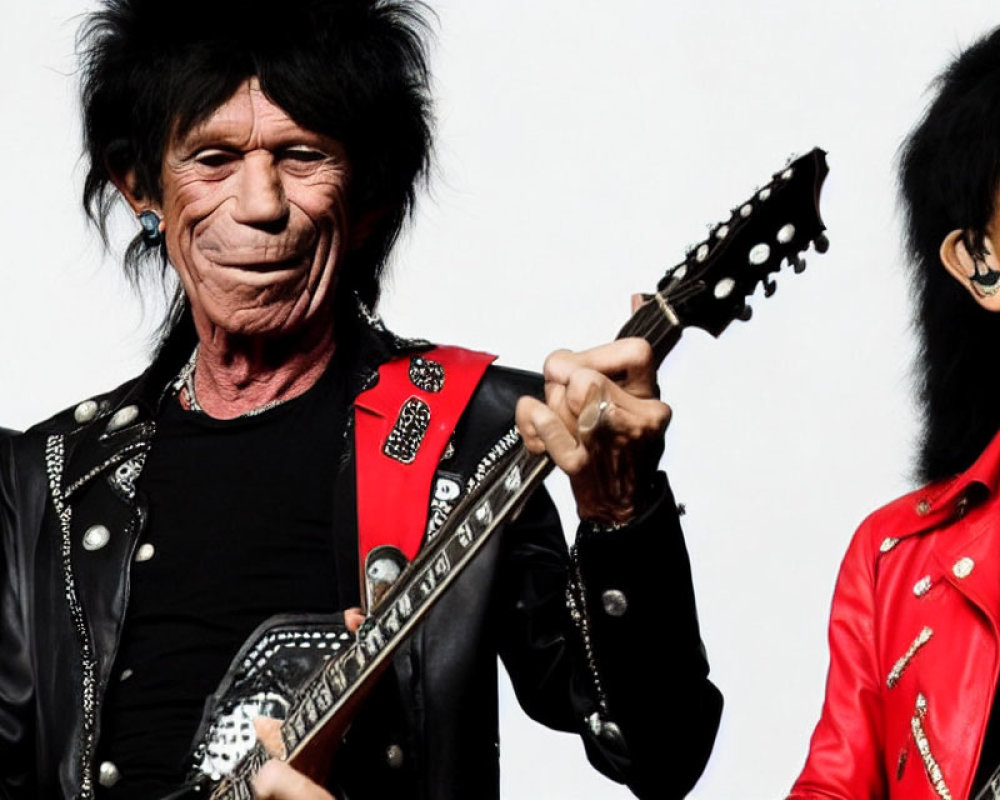 Joyful duo in red and black attire performing with guitar on stage