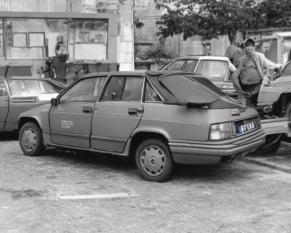 Monochrome photo of vintage sedan on city street