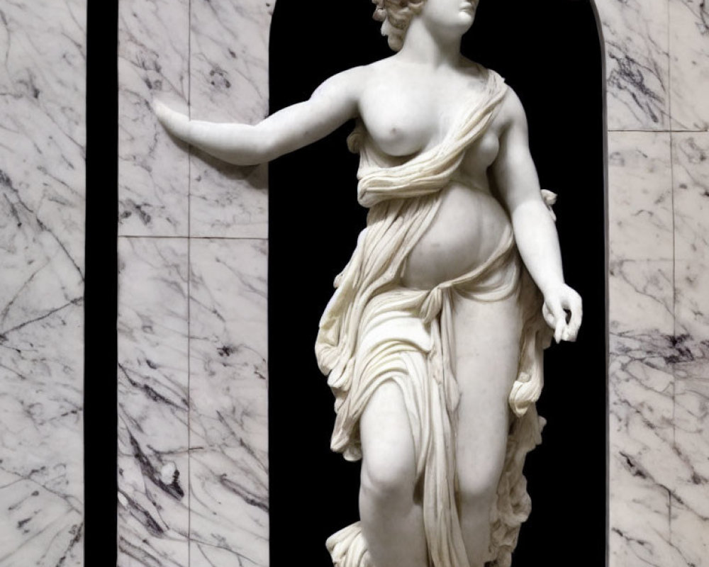 Classical marble statue of female figure with drapery against arch background