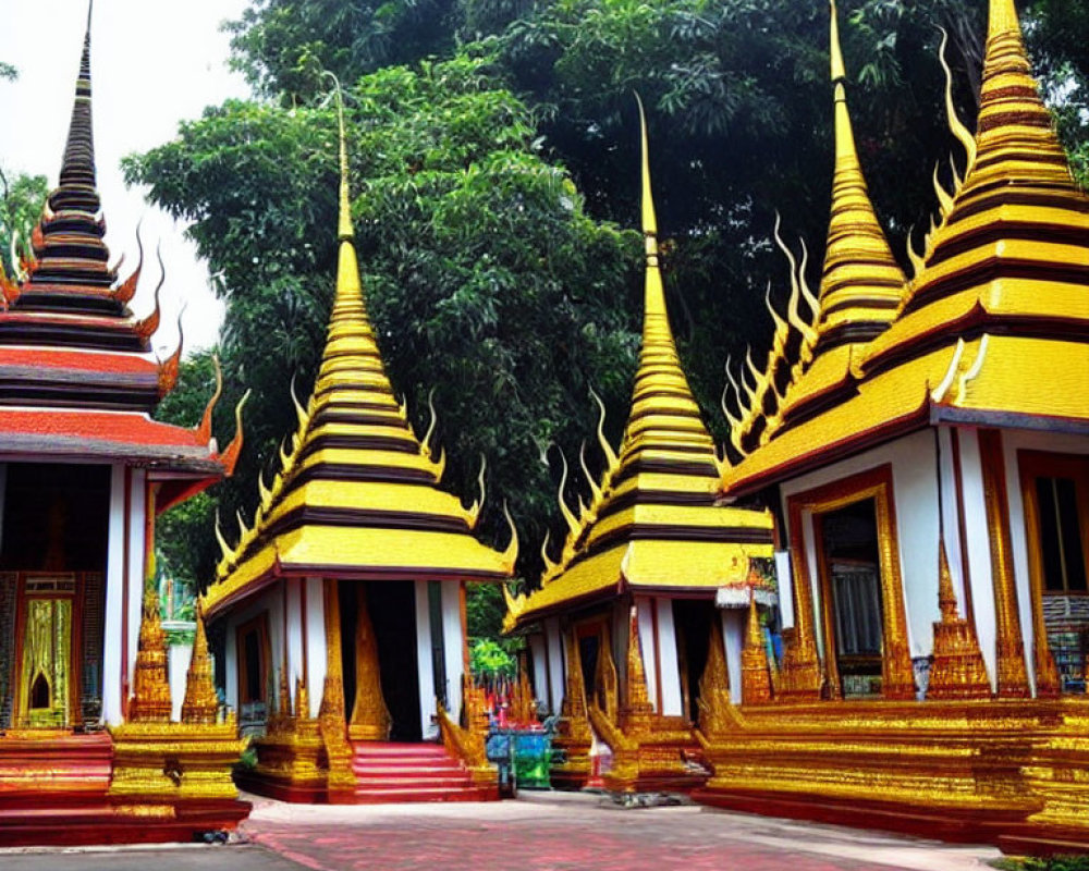 Traditional Thai-style pagodas with golden spires and red roofs amidst green trees under clear sky