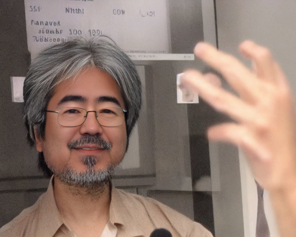 Salt-and-pepper Haired Man Smiling with Outstretched Hand in Foreground