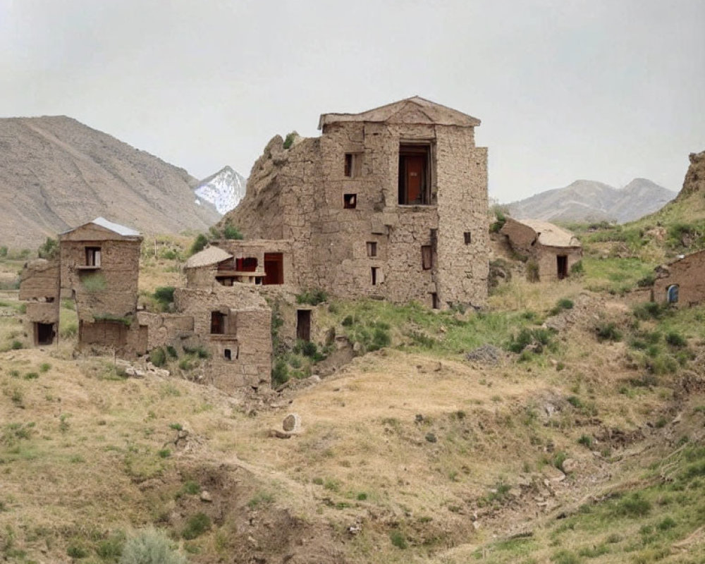 Rugged Landscape with Stone Houses and Snowy Mountains