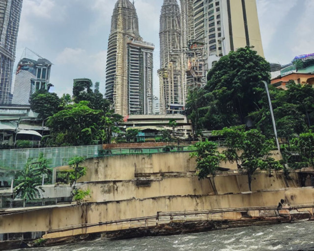 Turbulent river with moss-covered wall and modern skyscrapers under cloudy sky