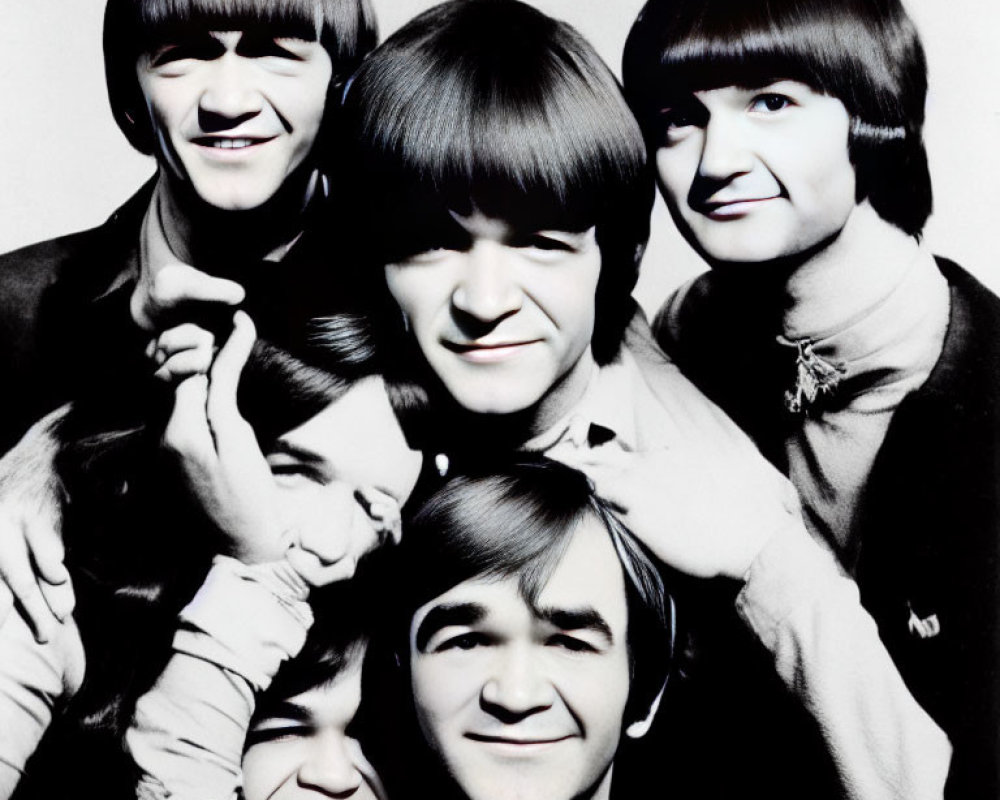 Group of men with bowl haircuts smiling in black and white photo