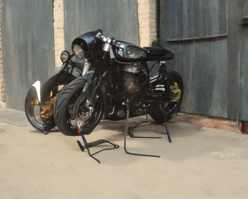 Black Motorcycle Parked in Front of Closed Garage Door with Brick Wall Background