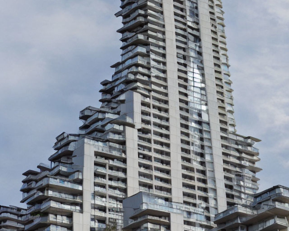 Contemporary high-rise with stacked balconies under cloudy sky