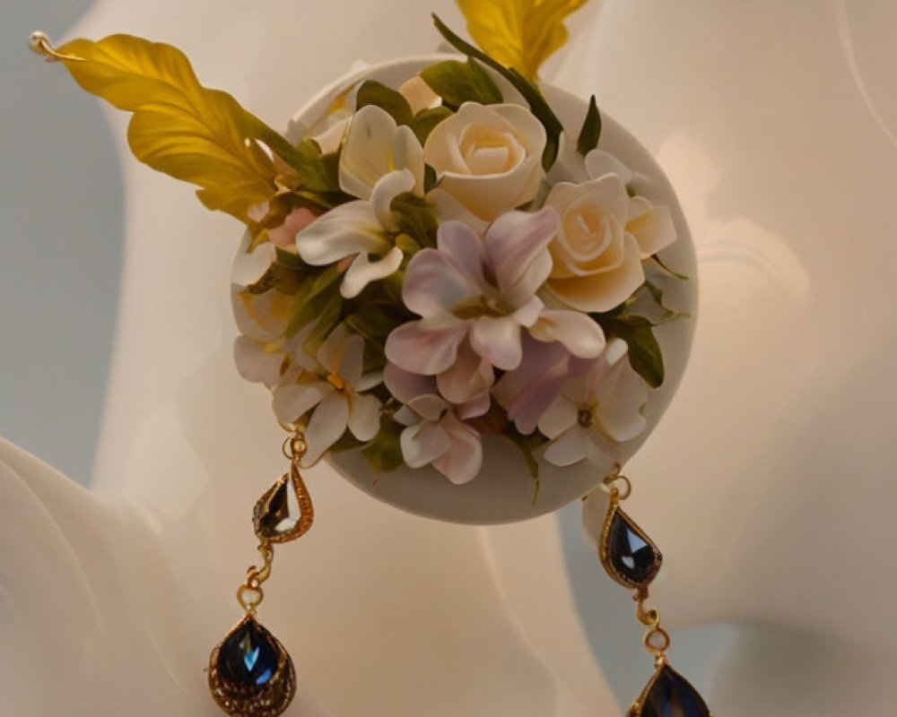 Mannequin bust with spherical floral arrangement and elegant blue gemstone earrings