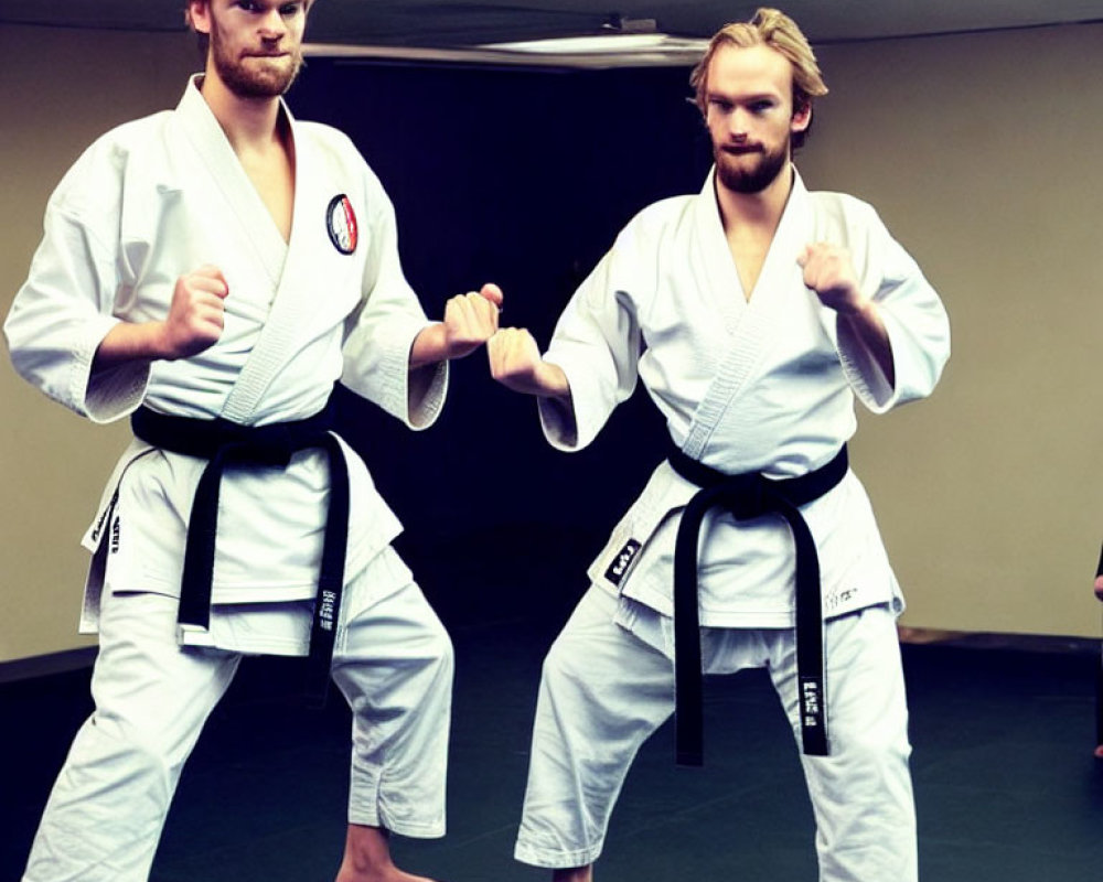 Martial Artists in White Gi and Black Belts Practicing in Dojo