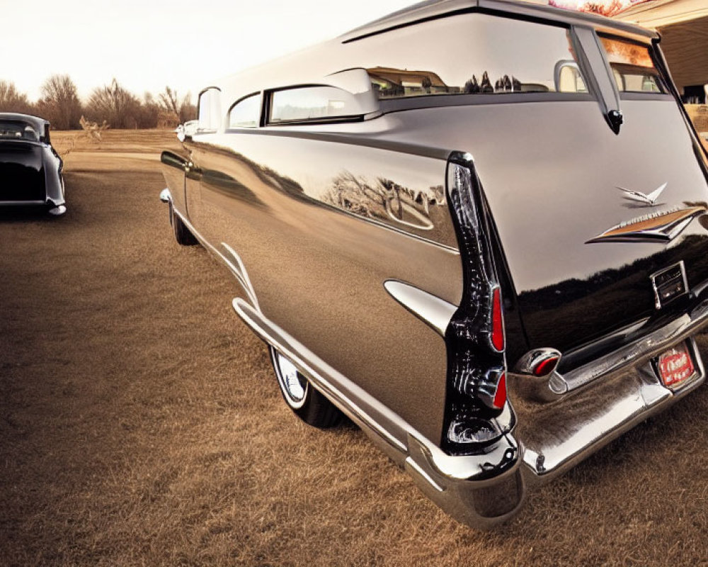 Vintage cars with distinctive tail fins and chrome details parked on a road under a soft sky.